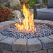 Bronson Block Round Gas Fire Pit Kit Placed at Frontyard with Tumbled Lava Rock Scaled plus Fire Burner On Zoom In