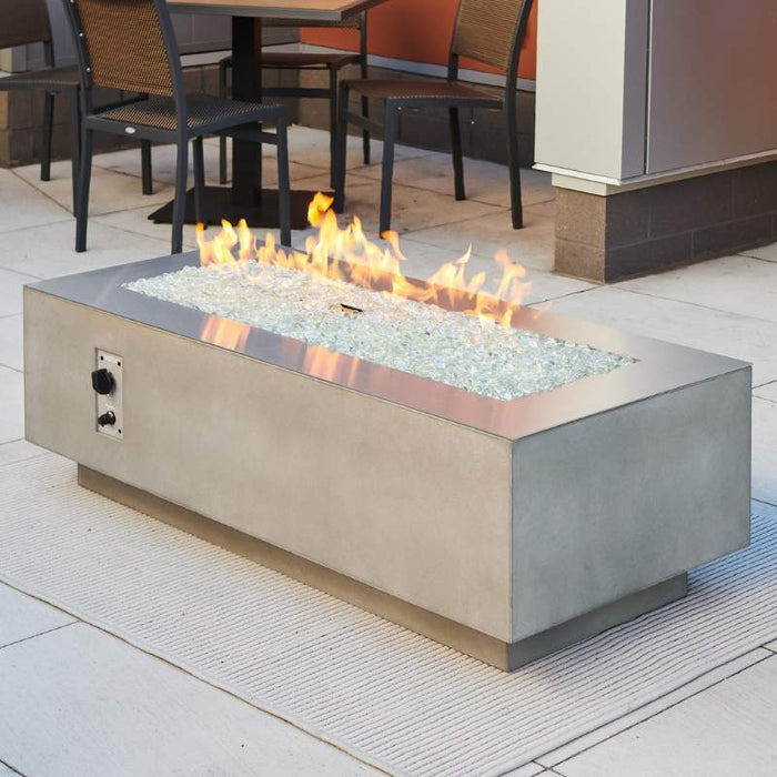 Natural Grey Cove 54 Linear Gas Fire Pit Table Installed at the Cafetheria with Clear Tempered Fire Glass Gems plus Fire Burner On and Stainless Steel Trim Overlay