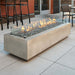 Natural Grey Cove 72 Linear Gas Fire Pit Table at the Front Yard with Tumbled Lava Rock plus Fire Burner On and Glass Wind Guard Installed