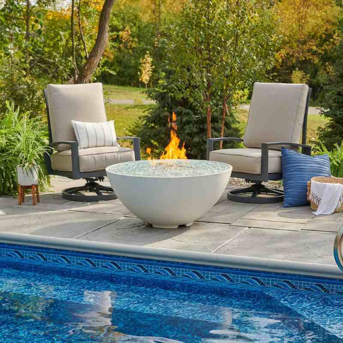 The Outdoor Greatroom White Cove Edge Round Gas Fire Pit Bowl place at Pool Side with Clear Tempered Fire Glass Gems plus Fire Burner On